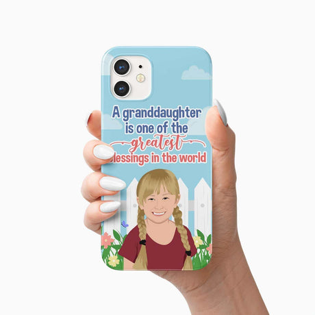 A hand holding a Granddaughter Greatest Blessings phone case with a protective layer featuring a sentimental message about granddaughters and an illustration of a smiling girl with braids by Ecomartists.