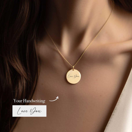 Woman wearing an Ecomartists Handwritten Personalized Necklace with a round pendant inscribed with "love you" in custom handwriting style.